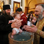 Patriarch Ilia baptizing a baby