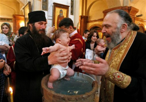 Patriarch Ilia baptizing a baby